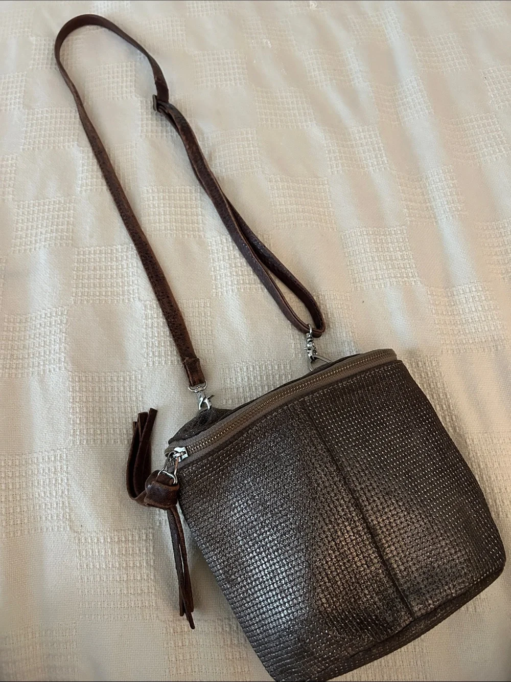 Daniella Lehavi leather crossbody bag features a silver/ brown woven texture.